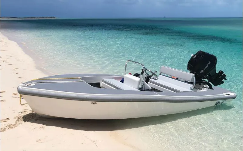 Slide: The Image of 2023 Ultra Lite Tenders 380 boat on a sandy beach with clear turquoise water. - 8