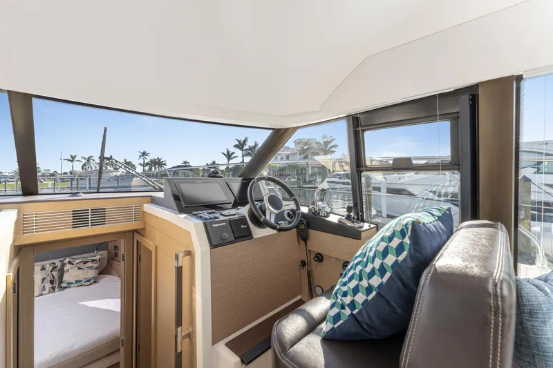 Slide: The Image of Interior of 2020 Prestige 420 Flybridge yacht with helm, seating, and scenic view. - 14