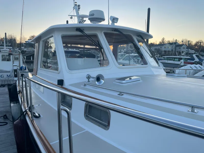 Slide: The Image of 2001 Grand Banks Eastbay 38 HX yacht docked in a serene marina at sunset. - 11