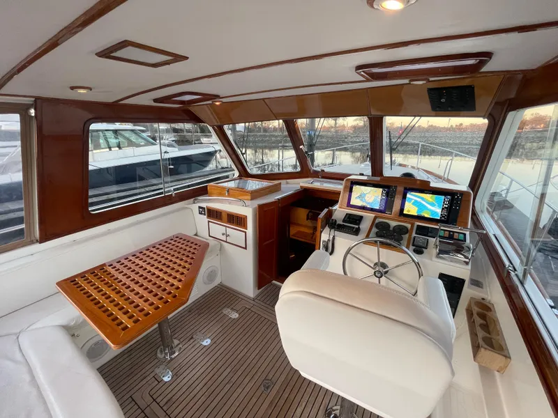 Slide: The Image of 2001 Grand Banks Eastbay 38 HX yacht interior with seating, table, and helm chair. - 25