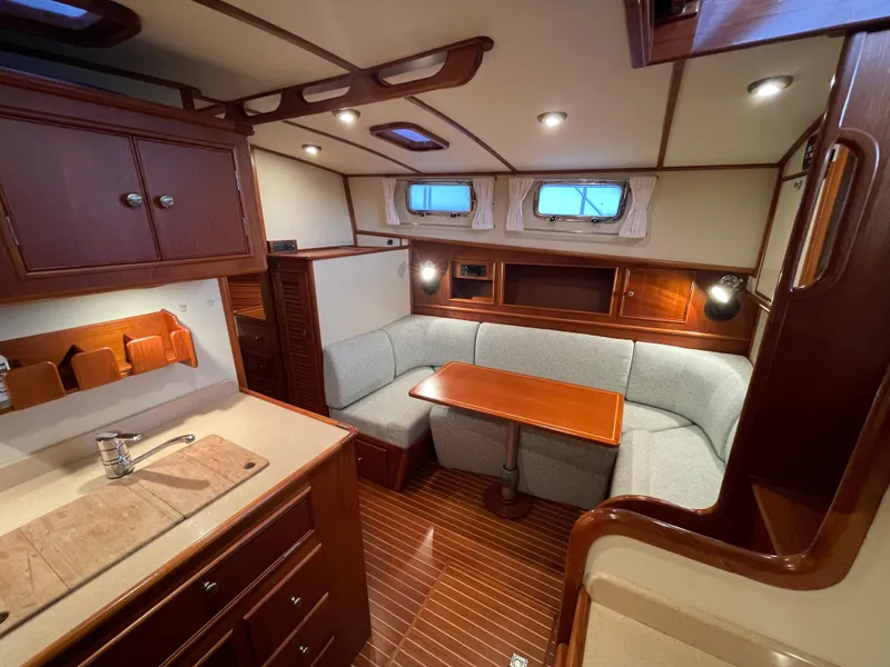 Slide: The Image of Interior of 2001 Grand Banks Eastbay 38 HX with cozy seating and wooden table. - 33