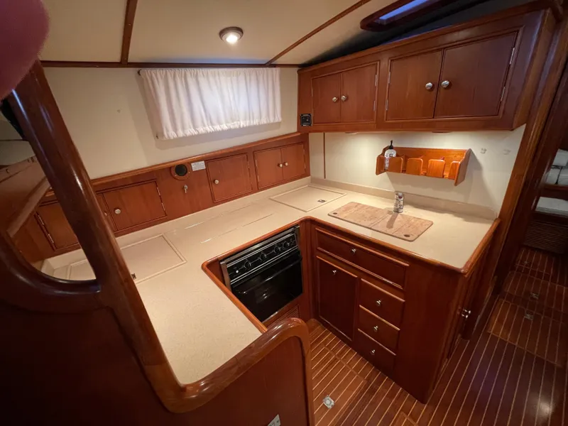 Slide: The Image of Interior of 2001 Grand Banks Eastbay 38 HX yacht with wood cabinetry and dining area. - 36