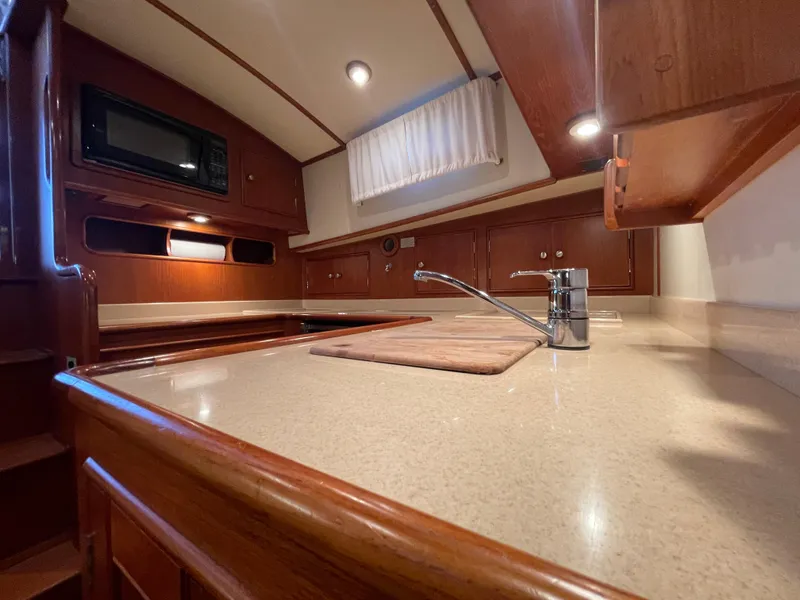 Slide: The Image of Luxurious 2001 Grand Banks Eastbay 38 HX yacht kitchen with wood cabinetry and modern appliances. - 37