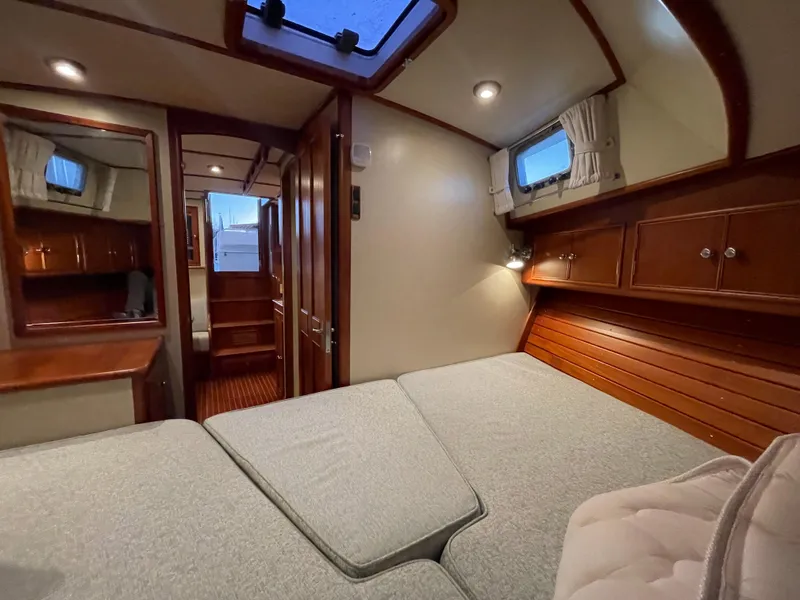 Slide: The Image of Cozy cabin interior of 2001 Grand Banks Eastbay 38 HX with wood finish and bed. - 42
