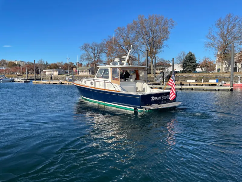 Slide: The Image of 2001 Grand Banks Eastbay 38 HX yacht on calm water, American flag displayed. - 6
