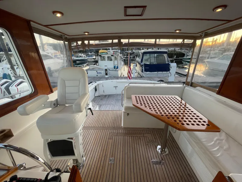 Slide: The Image of 2001 Grand Banks Eastbay 38 HX yacht interior with seating, table, and helm chair. - 24