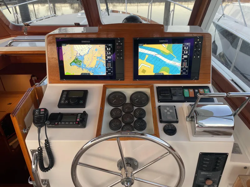 Slide: The Image of Helm of 2001 Grand Banks Eastbay 38 HX with navigation screens and controls. - 27