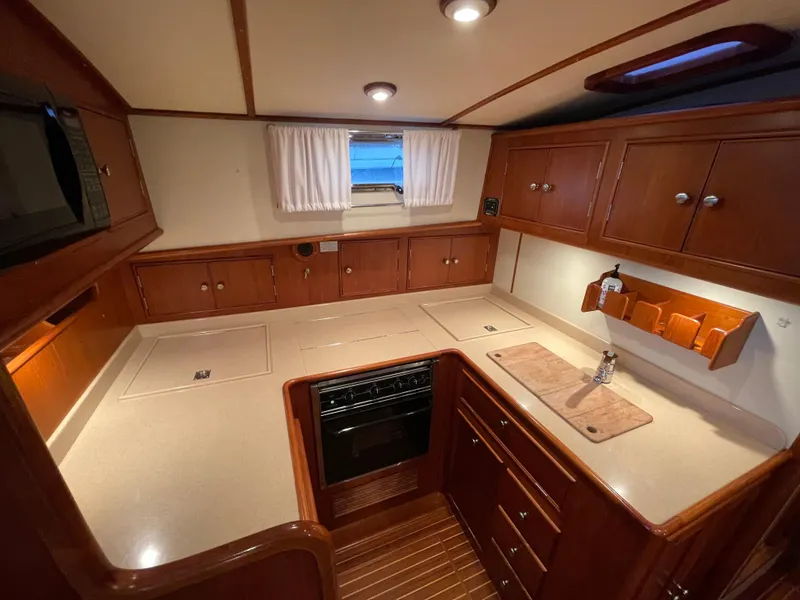 Slide: The Image of Luxurious 2001 Grand Banks Eastbay 38 HX yacht kitchen with wood cabinetry and modern appliances. - 38