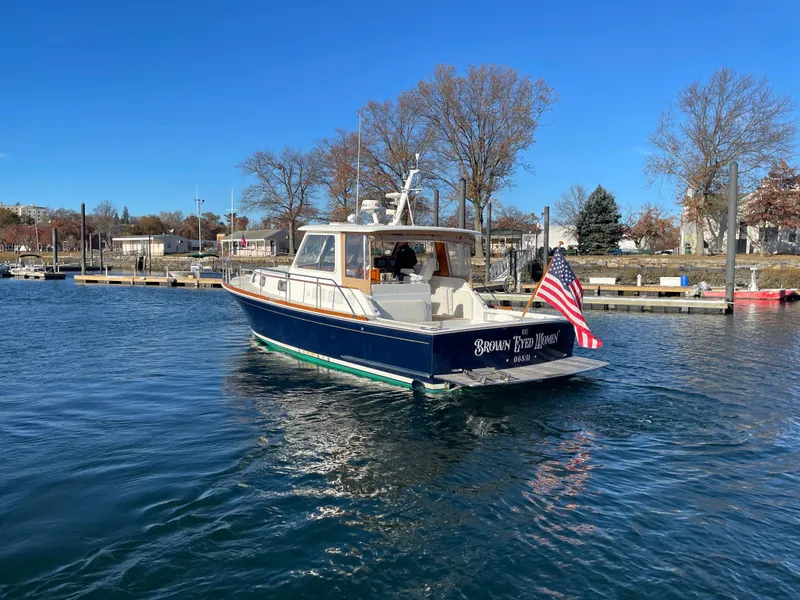 Slide: The Image of 2001 Grand Banks Eastbay 38 HX yacht on calm water, American flag displayed. - 4
