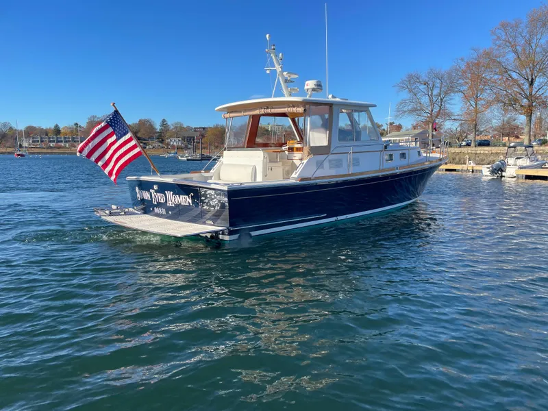Slide: The Image of 2001 Grand Banks Eastbay 38 HX yacht on water, displaying American flag. - 8