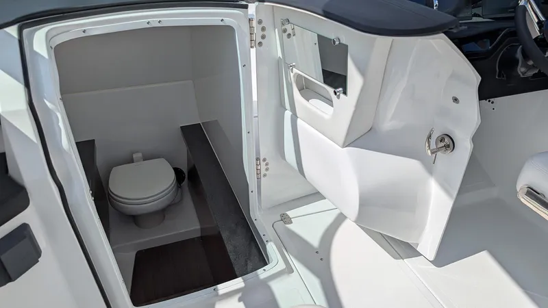 Slide: The Image of 2025 Four Winns H9 boat interior with compact bathroom and toilet. - 18