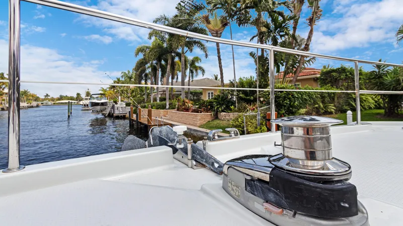 Slide: The Image of Fountaine Pajot MY 44 yacht, 2018, docked by a scenic waterfront with palm trees. - 7