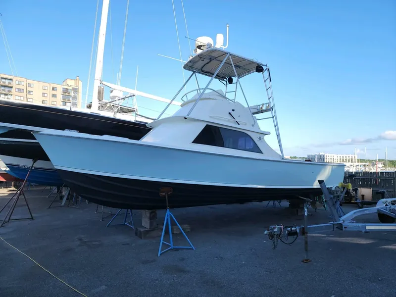 Slide: The Image of 1961 Bertram 31 Flybridge Cruiser on dry dock, blue sky background. - 2