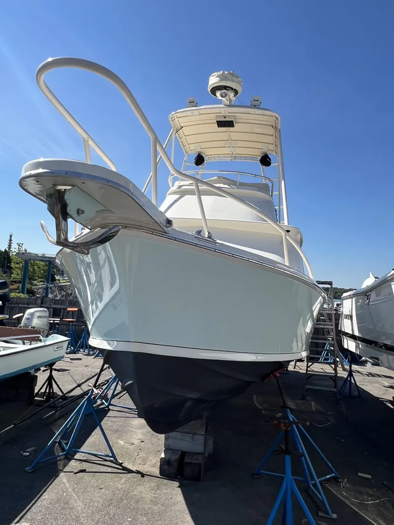 Slide: The Image of 1961 Bertram 31 Flybridge Cruiser on stands, viewed from the front under a clear blue sky. - 22
