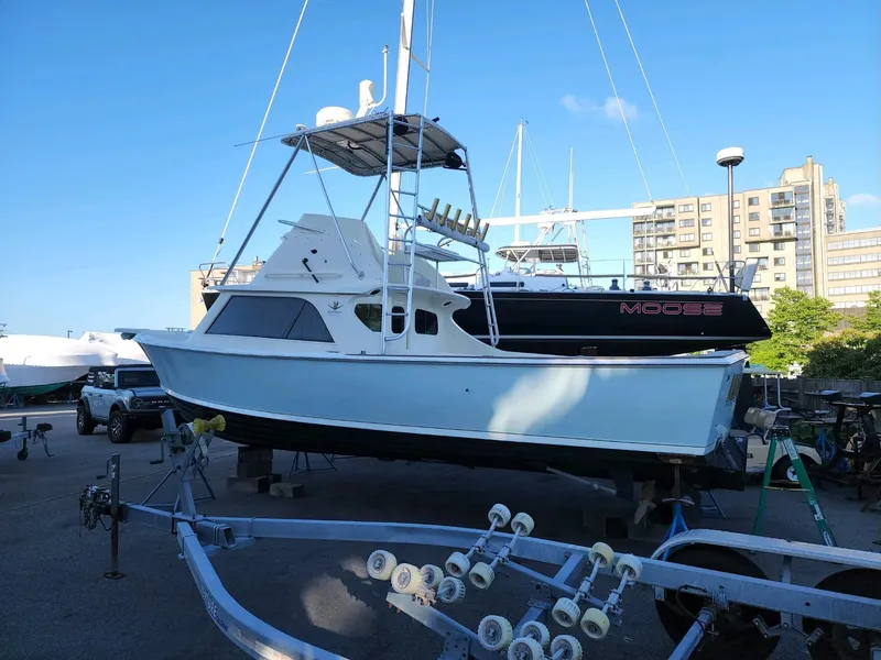 Slide: The Image of 1961 Bertram 31 Flybridge Cruiser on trailer, urban marina backdrop. - 24