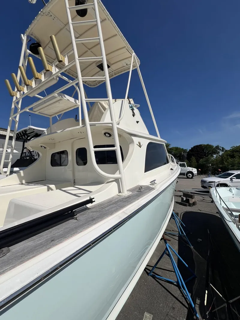 Slide: The Image of 1961 Bertram 31 Flybridge Cruiser with tower, docked under clear blue sky. - 5