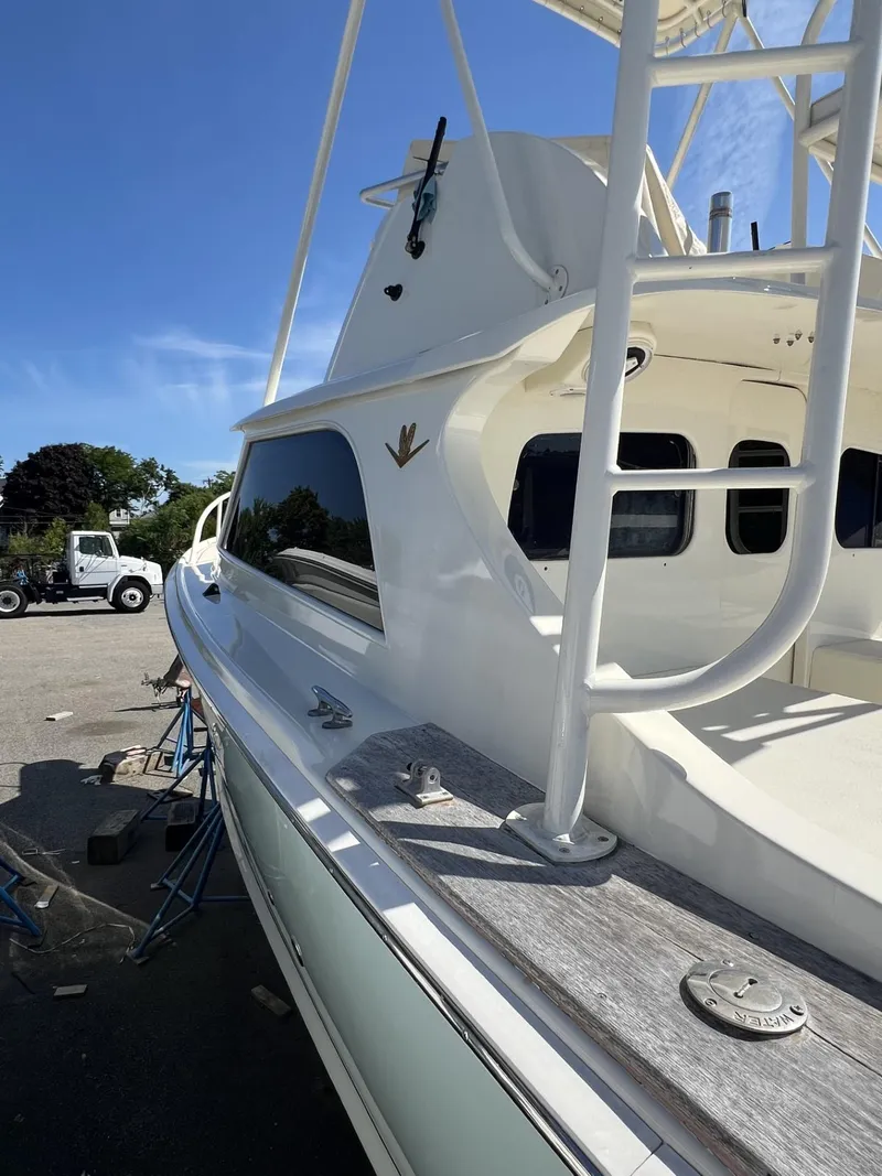 Slide: The Image of 1961 Bertram 31 Flybridge Cruiser with white exterior, docked under clear blue sky. - 6