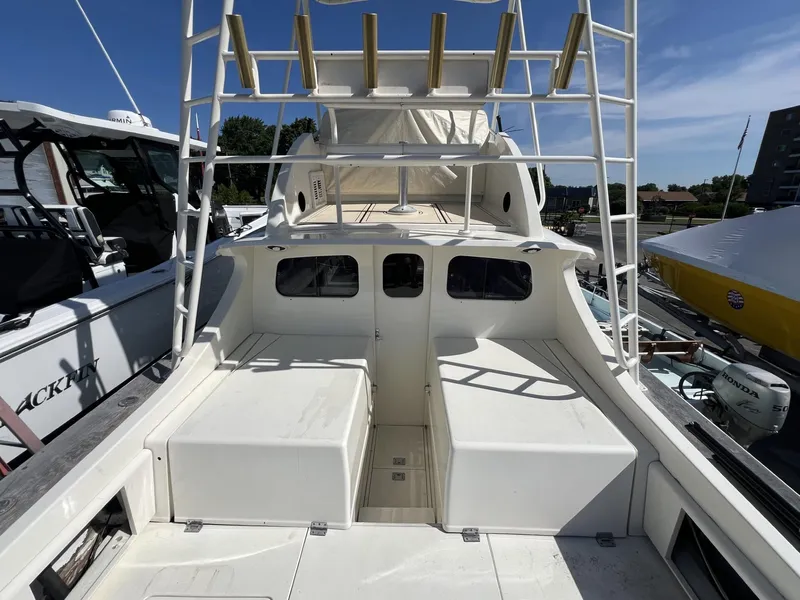 Slide: The Image of 1961 Bertram 31 Flybridge Cruiser, spacious deck view, classic design, docked under clear sky. - 8
