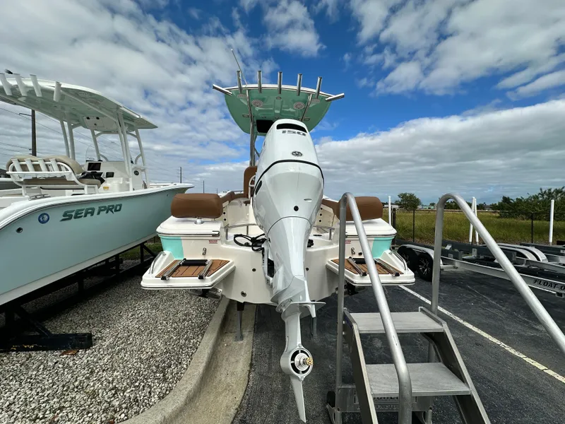 Slide: The Image of 2025 Pioneer 202 Sportfish boat with outboard motor, parked under a cloudy sky. - 3
