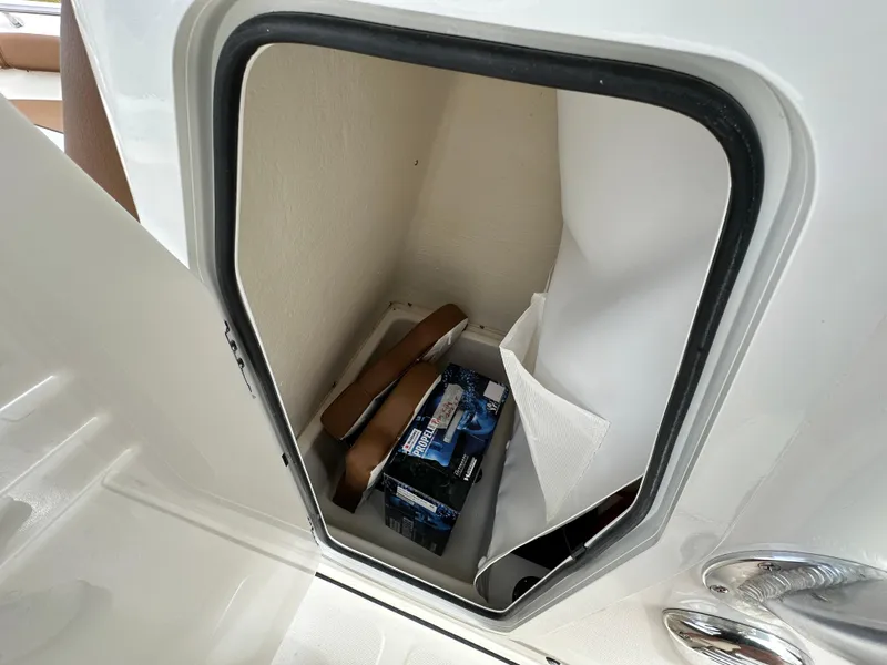 Slide: The Image of Storage compartment in 2025 Pioneer 202 Sportfish boat, featuring interior items and secure door. - 7