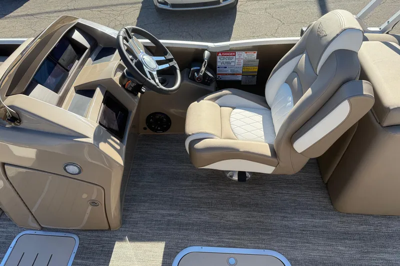 Slide: The Image of 2025 Bennington L Bowrider Line boat interior with steering wheel and captain's chair. - 12