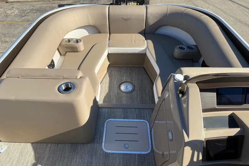 Slide: The Image of 2025 Bennington L Bowrider Line interior with beige seating and cup holders. - 8