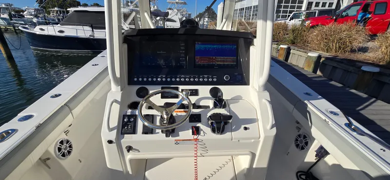 Slide: The Image of 2021 Regulator 34 Center Console boat dashboard with steering wheel and navigation screens. - 1