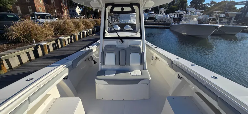 Slide: The Image of 2021 Regulator 34 Center Console boat docked at marina, showcasing spacious seating and sleek design. - 10