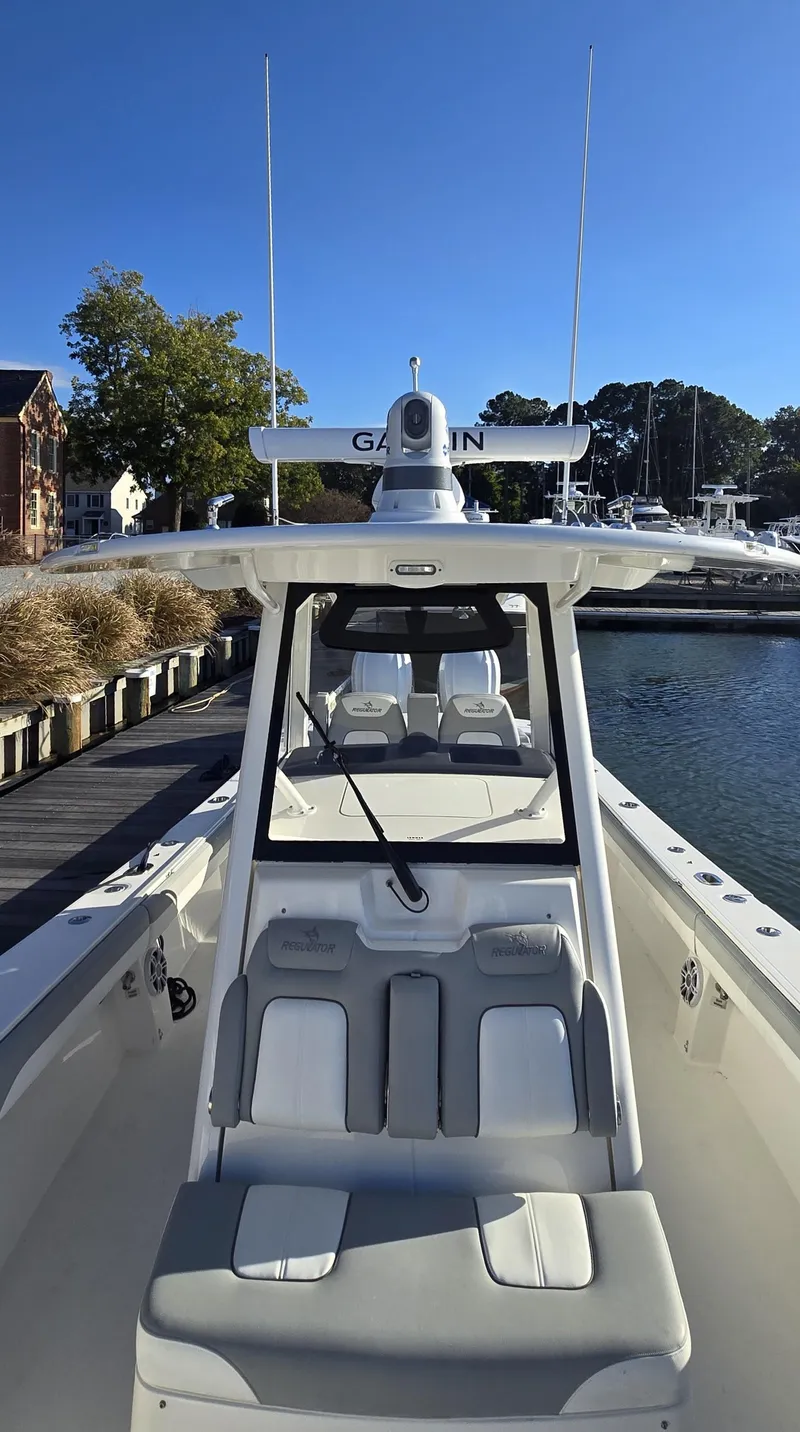 Slide: The Image of 2021 Regulator 34 Center Console boat docked in a marina under clear blue skies. - 11
