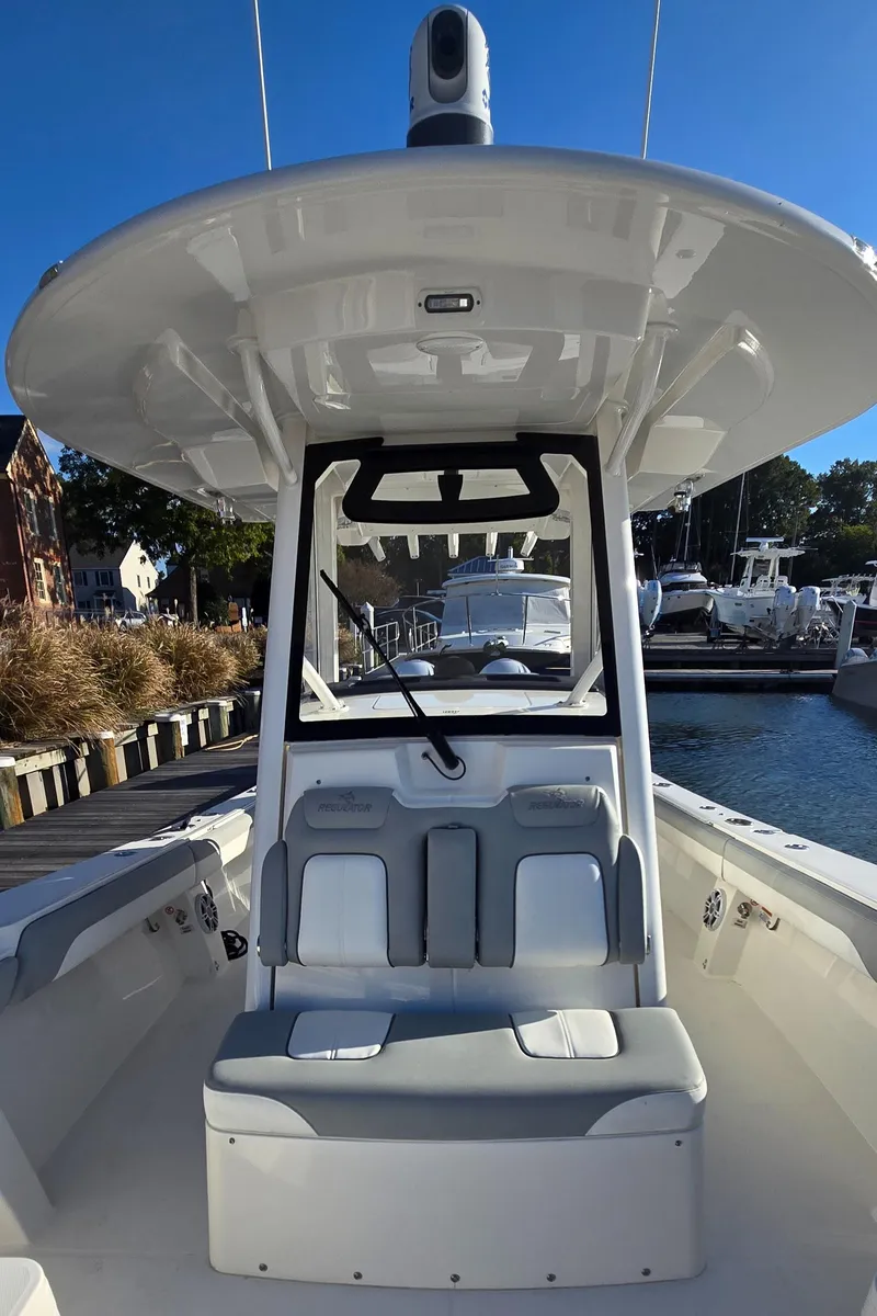 Slide: The Image of 2021 Regulator 34 Center Console boat docked at a marina, showcasing seating and helm. - 12