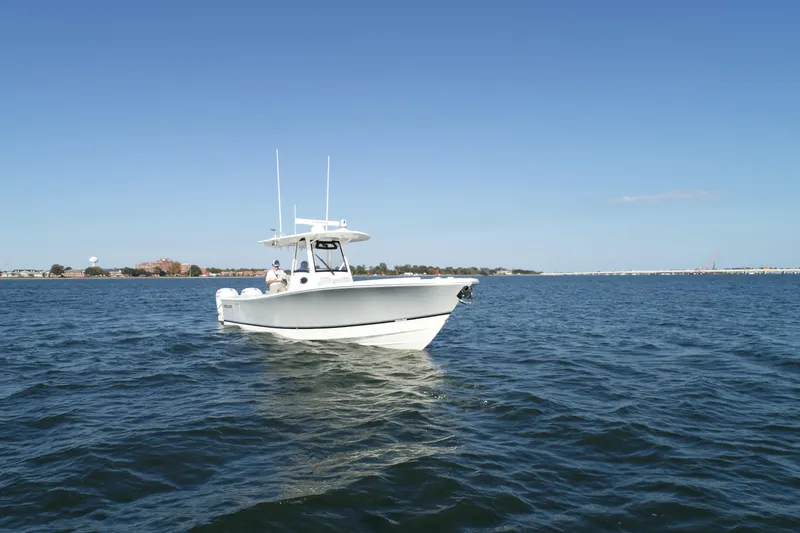 Slide: The Image of 2021 Regulator 34 Center Console boat on open water under clear blue sky. - 20