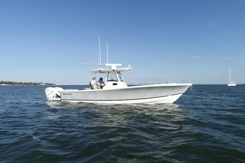 Slide: The Image of 2021 Regulator 34 Center Console boat on open water under clear blue sky. - 21