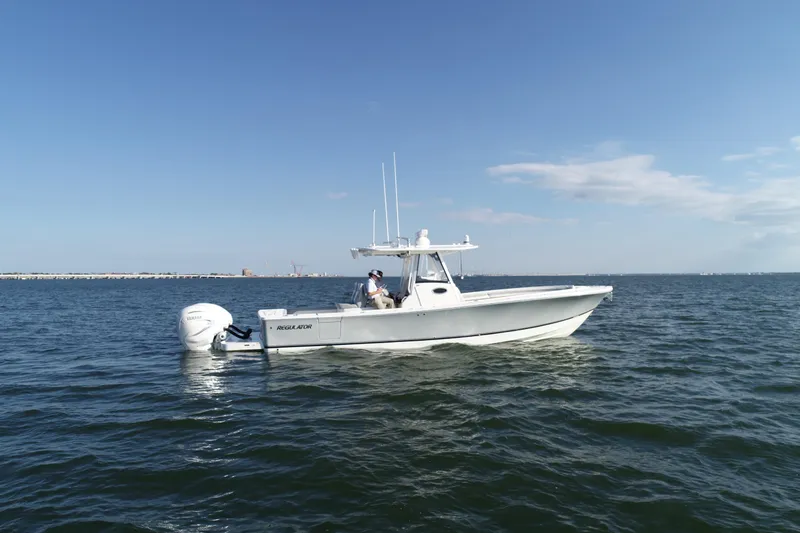 Slide: The Image of 2021 Regulator 34 Center Console boat on open water under clear sky. - 22