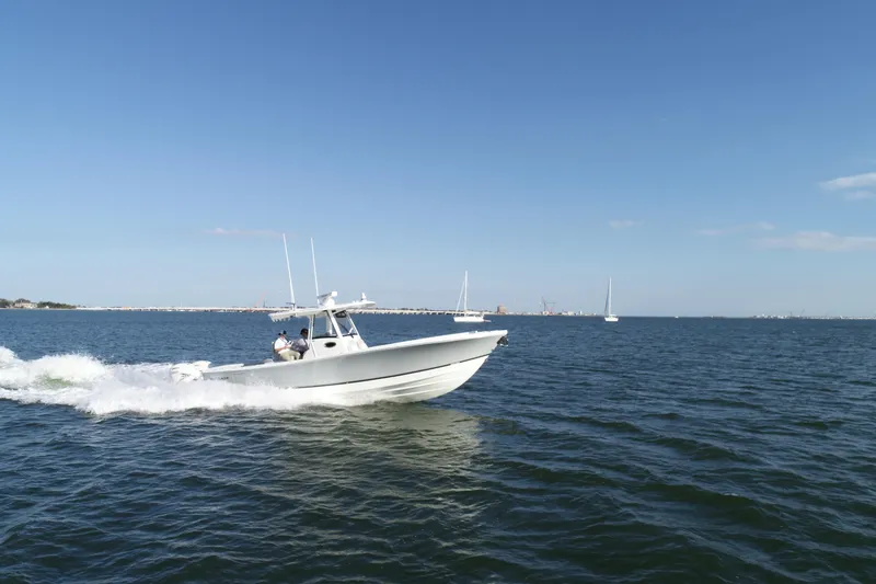 Slide: The Image of 2021 Regulator 34 Center Console boat cruising on open water under clear skies. - 24