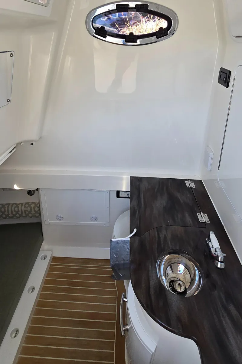 Slide: The Image of 2021 Regulator 34 Center Console interior with sink and wooden flooring. - 5