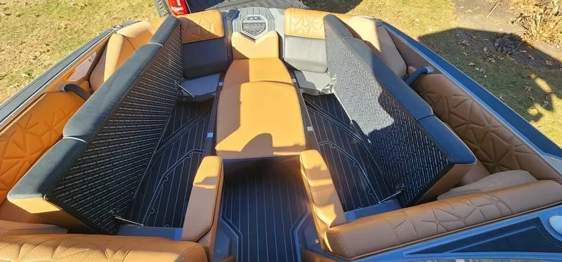 Slide: The Image of Luxurious interior of 2022 Nautique G25 Paragon boat with tan and black seating. - 31
