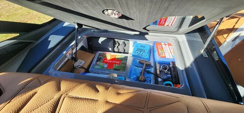 Slide: The Image of Storage compartment in 2022 Nautique G25 Paragon boat with safety and utility items. - 33