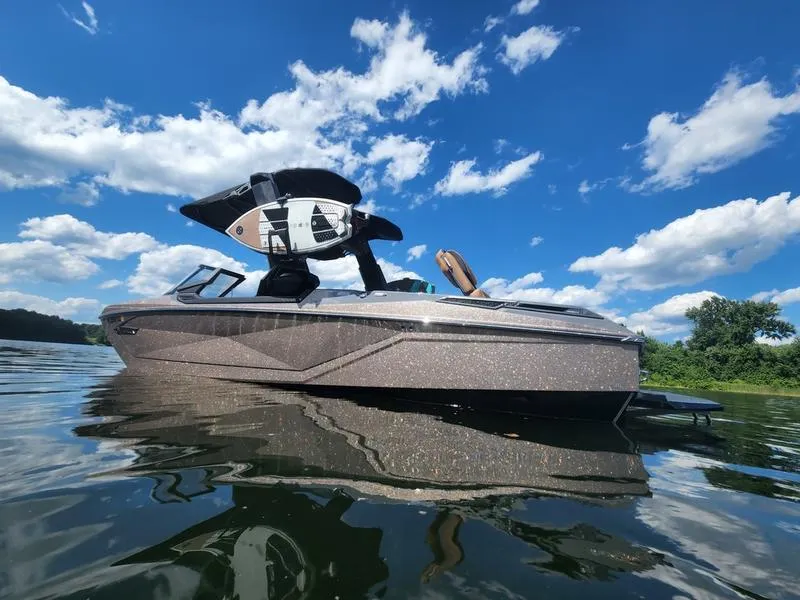 Slide: The Image of 2022 Nautique G25 Paragon boat on a sunny lake with blue skies. - 4