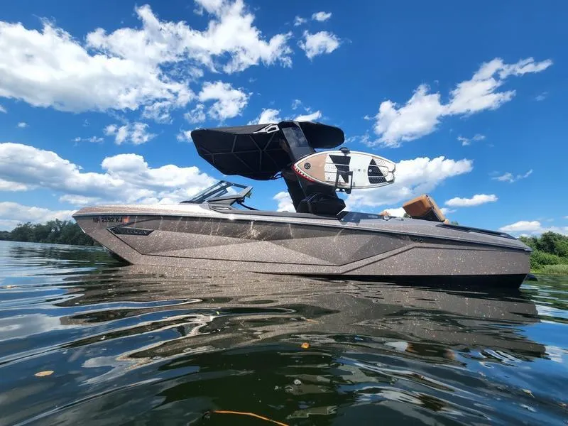 Slide: The Image of 2022 Nautique G25 Paragon boat on a sunny lake with blue skies. - 5
