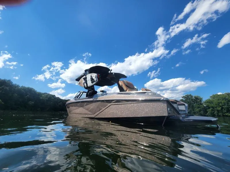 Slide: The Image of 2022 Nautique G25 Paragon boat on a sunny lake with blue skies. - 6
