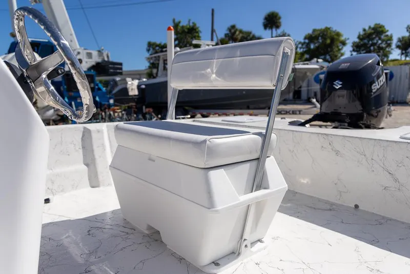 Slide: The Image of 2025 Coastal Skiff 184 boat interior with white seating and steering wheel. - 10