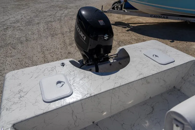 Slide: The Image of 2025 Coastal Skiff 184 boat with Suzuki outboard motor on a sandy surface. - 12