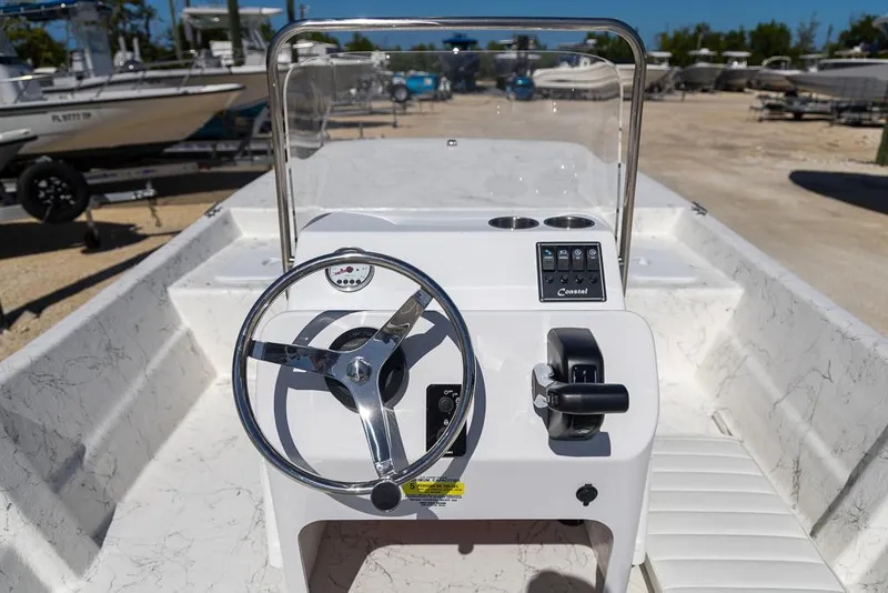 Slide: The Image of 2025 Coastal Skiff 184 boat interior with steering wheel and controls. - 13