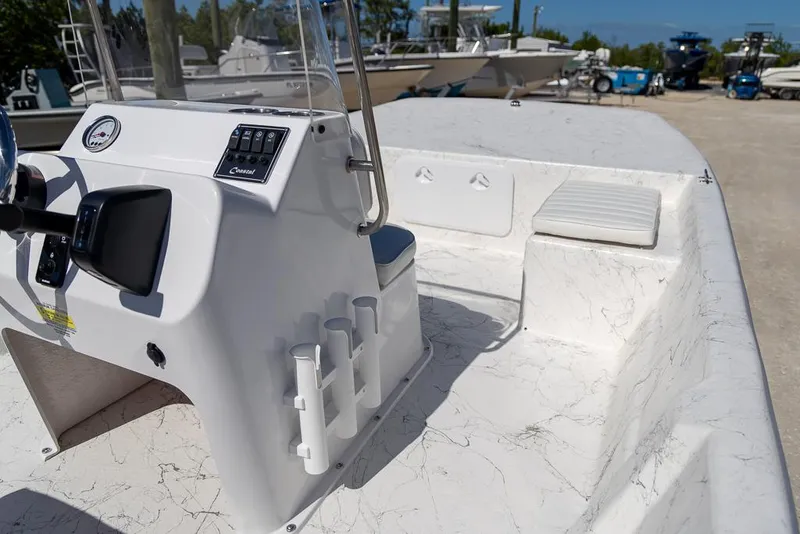 Slide: The Image of 2025 Coastal Skiff 184 boat interior with console and seating, parked outdoors. - 19