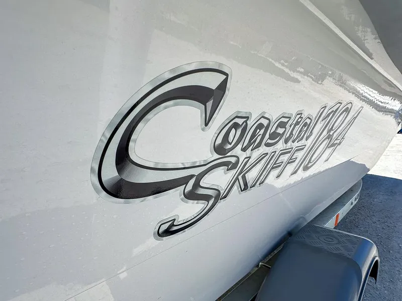 Slide: The Image of 2025 Coastal Skiff 184 boat logo on hull, close-up view. - 7