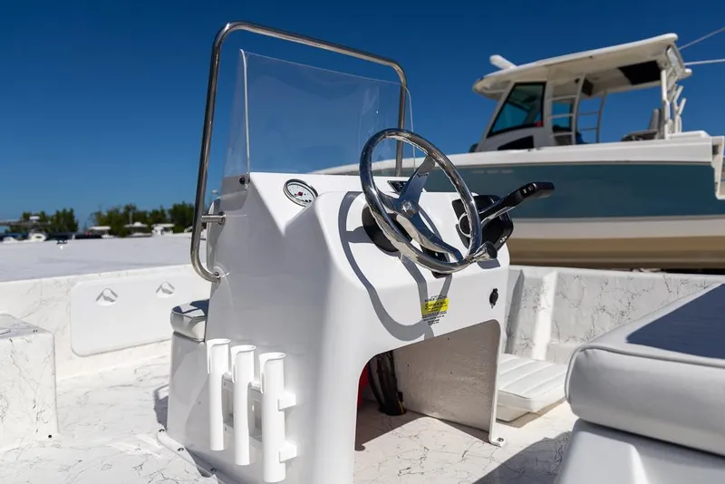 Slide: The Image of 2025 Coastal Skiff 184 boat console with steering wheel, sunny day. - 9