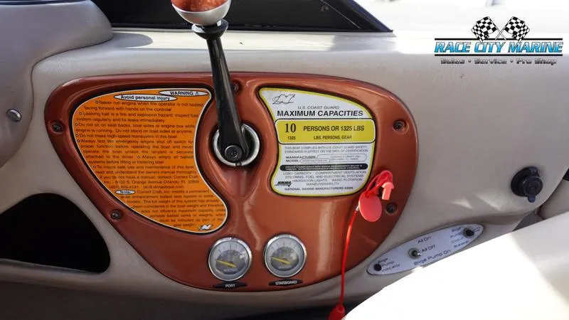 Slide: The Image of 2003 Nautique Air Nautique 216 dashboard with capacity and safety labels. - 24