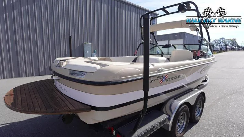 Slide: The Image of 2003 Nautique Air Nautique 216 boat on trailer, parked outside a marine shop. - 8