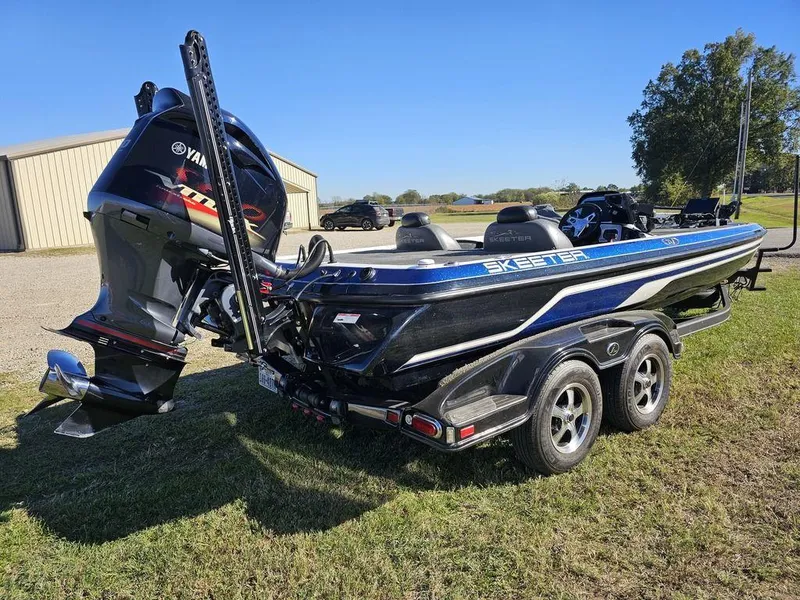 Slide: The Image of 2013 Skeeter 21i boat with Yamaha engine on a trailer, parked on grass. - 9