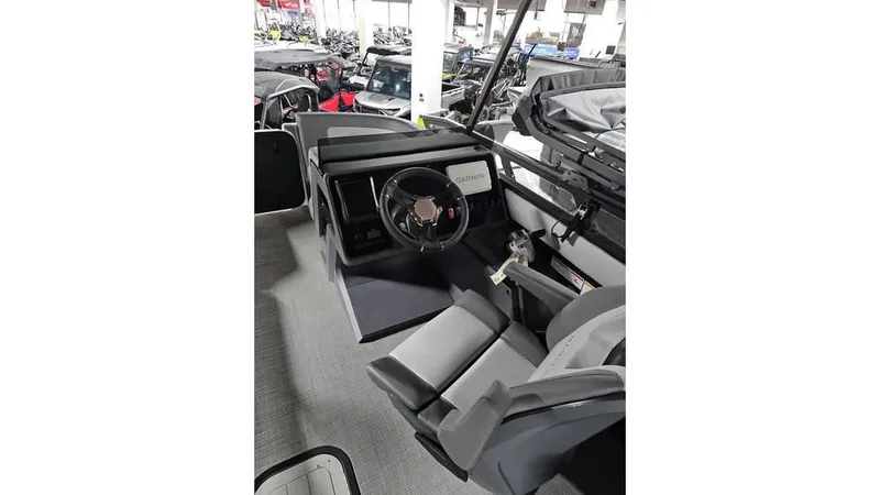 Slide: The Image of 2025 Manitou 20 CRUISE MAX boat interior with steering wheel and seating. - 13